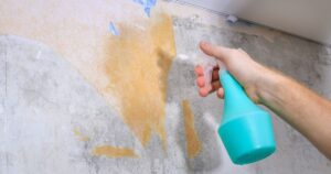 0_A-man-removes-old-wallpaper-with-a-spatula-and-spray-bottle-with-water.jpg