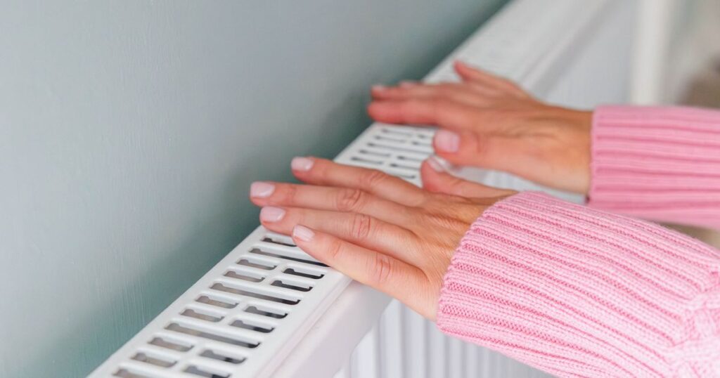 0_Close-up-of-a-woman-hands-in-a-pink-jumper-keeping-warm-by-a-heating-radiator.jpg