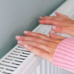 0_Close-up-of-a-woman-hands-in-a-pink-jumper-keeping-warm-by-a-heating-radiator.jpg
