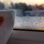 0_Close-up-view-of-person-hand-using-paper-cloth-drying-wet-condensation-drops-from-glass-window-in.jpeg