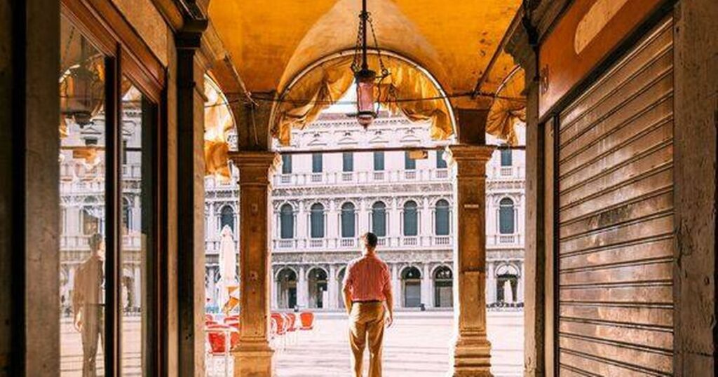 0_Rear-view-of-a-man-standing-in-the-arch-looking-at-Piazza-San-Marco-square-in-Venice-Italy.jpg