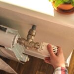 0_Woman-adjusting-the-temperature-on-valve-of-a-radiator-at-home-modern-interior-background-photo.jp_.jpeg