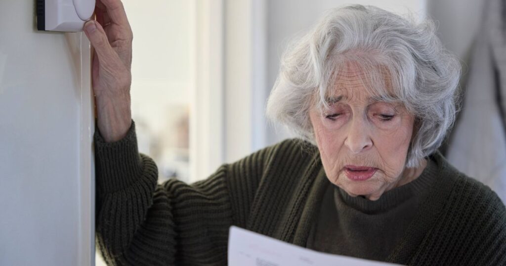 0_Worried-Senior-Woman-With-Bill-Turning-Down-Central-Heating-Thermostat-At-Home-In-Energy-Crisis.jp_.jpeg