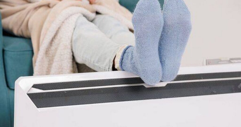 0_Young-girl-in-warm-knitted-socks-warms-her-feet-on-a-radiator-Heating-season-concept.jpg