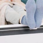 0_Young-girl-in-warm-knitted-socks-warms-her-feet-on-a-radiator-Heating-season-concept.jpg