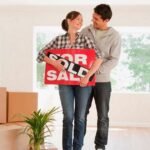 16_Couple-holding-sold-sign-for-their-new-house.jpg