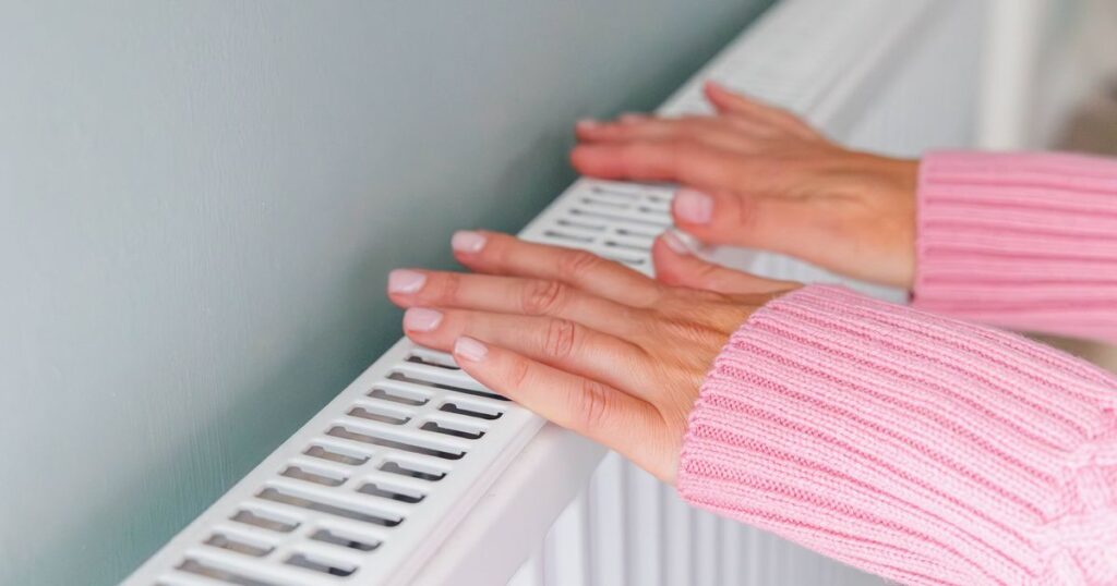 1763463365_0_Close-up-of-a-woman-hands-in-a-pink-jumper-keeping-warm-by-a-heating-radiator.jpg
