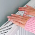 1763463365_0_Close-up-of-a-woman-hands-in-a-pink-jumper-keeping-warm-by-a-heating-radiator.jpg
