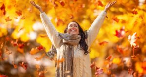 1_A-happy-young-woman-in-a-park-throws-leaves-during-an-Indian-summer-and-enjoys-autumn.jpg