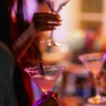 1_Close-Up-of-A-Martini-Glass-Held-By-A-Female-At-A-Bar.jpg