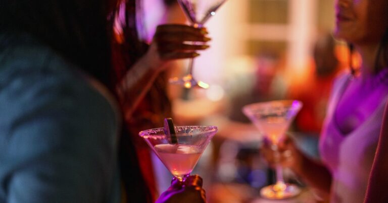 1_Close-Up-of-A-Martini-Glass-Held-By-A-Female-At-A-Bar.jpg