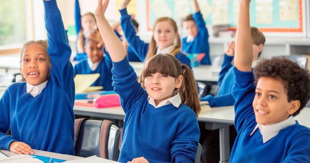 2_Elementary-school-children-wearing-blue-school-uniforms-raising-hands-in-classroom.jpg