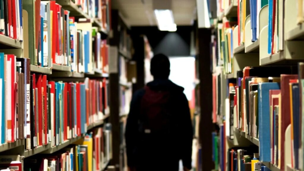 un-hombre-pasea-por-el-pasillo-de-una-biblioteca.jpeg