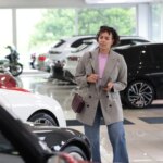 woman-looking-cars-showroom-1014462515.jpg