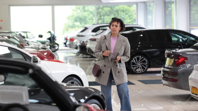 woman-looking-cars-showroom-1014462515.jpg