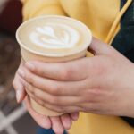 0_Bio-paper-cup-with-coffee-latte-art-in-woman-hand-Young-stylish-hipster-redhead-girl-drinking-hot.jpeg