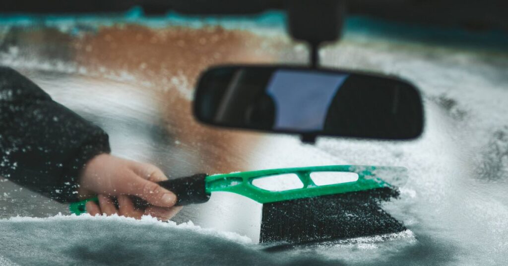 0_Cleaning-a-windshield-in-a-vehicle-A-hand-with-a-brush-removes-snow-and-ice-from-the-car.jpg