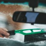 0_Cleaning-a-windshield-in-a-vehicle-A-hand-with-a-brush-removes-snow-and-ice-from-the-car.jpg