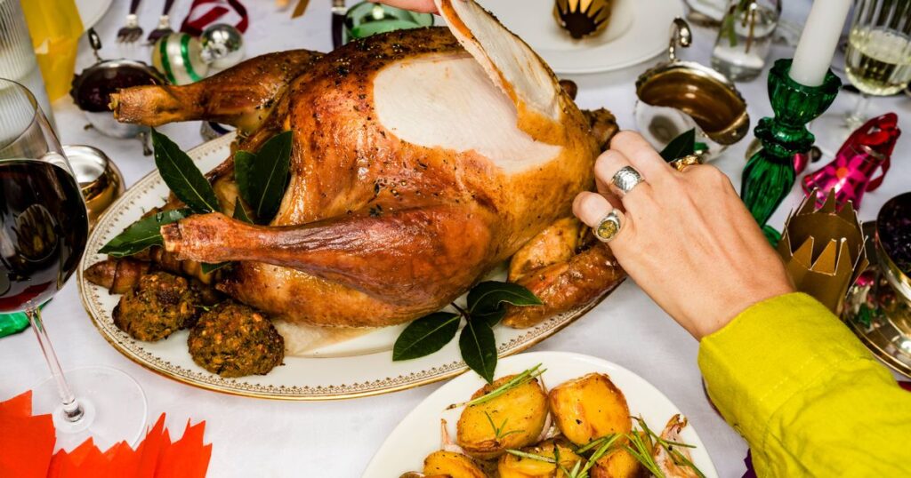 0_Close-up-friends-carving-roasted-turkey-at-Christmas-dinner-table.jpg