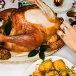 0_Close-up-friends-carving-roasted-turkey-at-Christmas-dinner-table.jpg