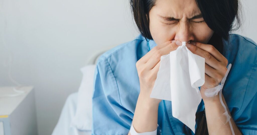 0_Close-up-of-Asian-female-patient-sneezing-in-tissue-cause-of-cold-and-flu-while-admitted-at-hospit.jpeg