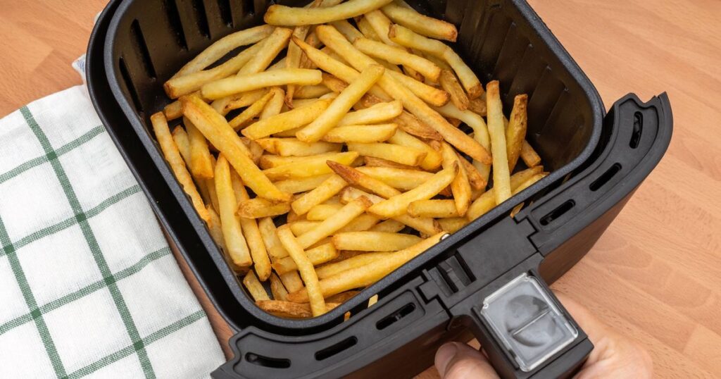 0_HAND-HOLDING-AIR-FRYER-BASKET-WITH-FRESHLY-MADE-FRENCH-FRIES-OR-FRIED-POTATOES-IN-THE-KITCHEN-TOP.jpeg