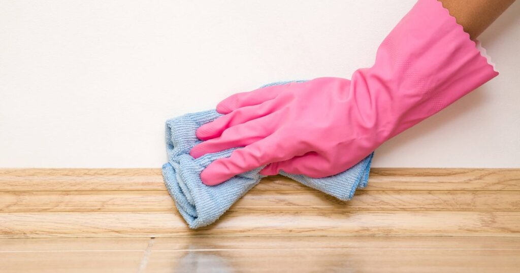 0_Hand-in-rubber-protective-glove-cleaning-baseboard-on-the-floor-from-dust-with-rag-at-the-wall-Ear.jpeg