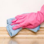 0_Hand-in-rubber-protective-glove-cleaning-baseboard-on-the-floor-from-dust-with-rag-at-the-wall-Ear.jpeg