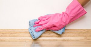 0_Hand-in-rubber-protective-glove-cleaning-baseboard-on-the-floor-from-dust-with-rag-at-the-wall-Ear.jpeg