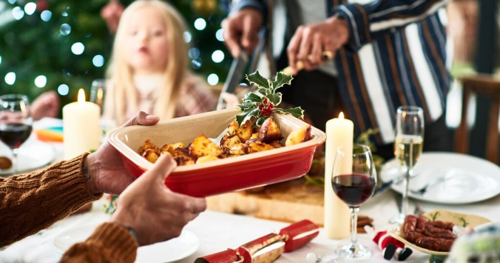 0_Man-holding-serving-dish-with-roast-potatoes-and-a-sprig-of-holly-for-Christmas-dinner.jpg