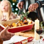 0_Man-holding-serving-dish-with-roast-potatoes-and-a-sprig-of-holly-for-Christmas-dinner.jpg