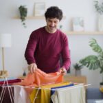 0_Smiling-man-hanging-clean-laundry-at-home.jpg