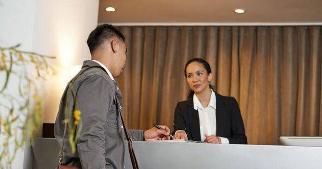 0_Traveller-Checking-In-at-a-Hotel-Reception-Desk-with-Friendly-Staff-Interaction.jpg
