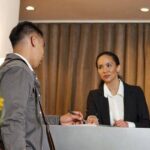 0_Traveller-Checking-In-at-a-Hotel-Reception-Desk-with-Friendly-Staff-Interaction.jpg