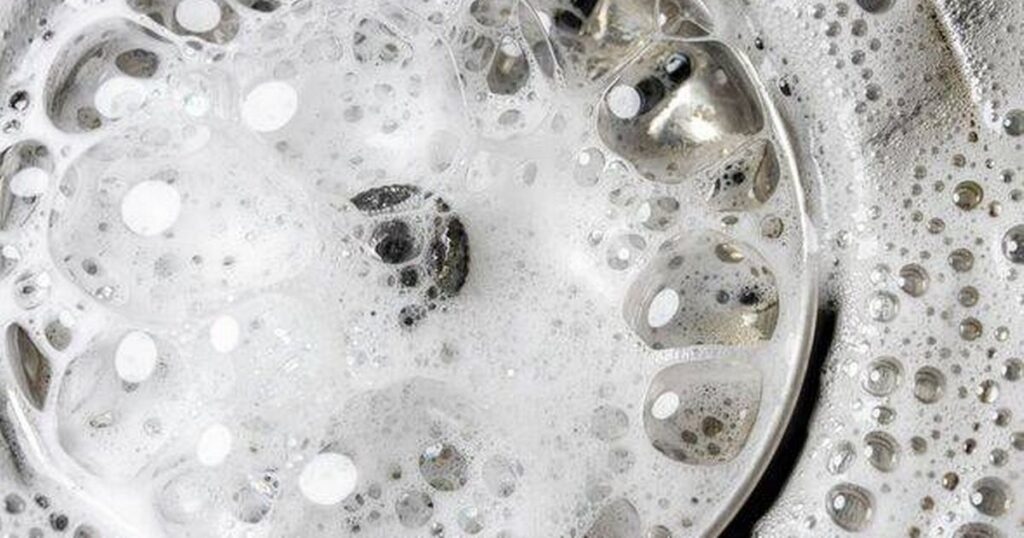 0_White-foam-with-bubbles-of-cleaner-in-a-washbasin-macro-view-Drain-hole-with-soap-bubbles-in-metal.jpeg