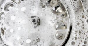 0_White-foam-with-bubbles-of-cleaner-in-a-washbasin-macro-view-Drain-hole-with-soap-bubbles-in-metal.jpeg