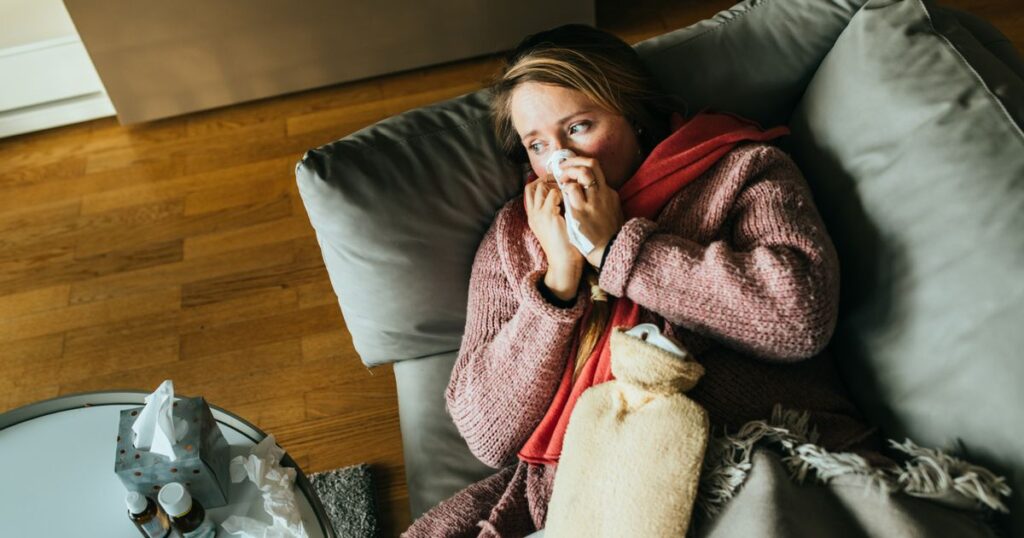 0_Woman-lying-on-a-sofa-while-having-a-flu-and-feeling-sick-and-sneezing.jpg