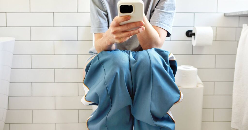 0_Woman-sitting-on-toilet-using-smartphone-in-modern-bathroom.jpg