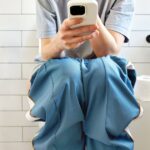 0_Woman-sitting-on-toilet-using-smartphone-in-modern-bathroom.jpg