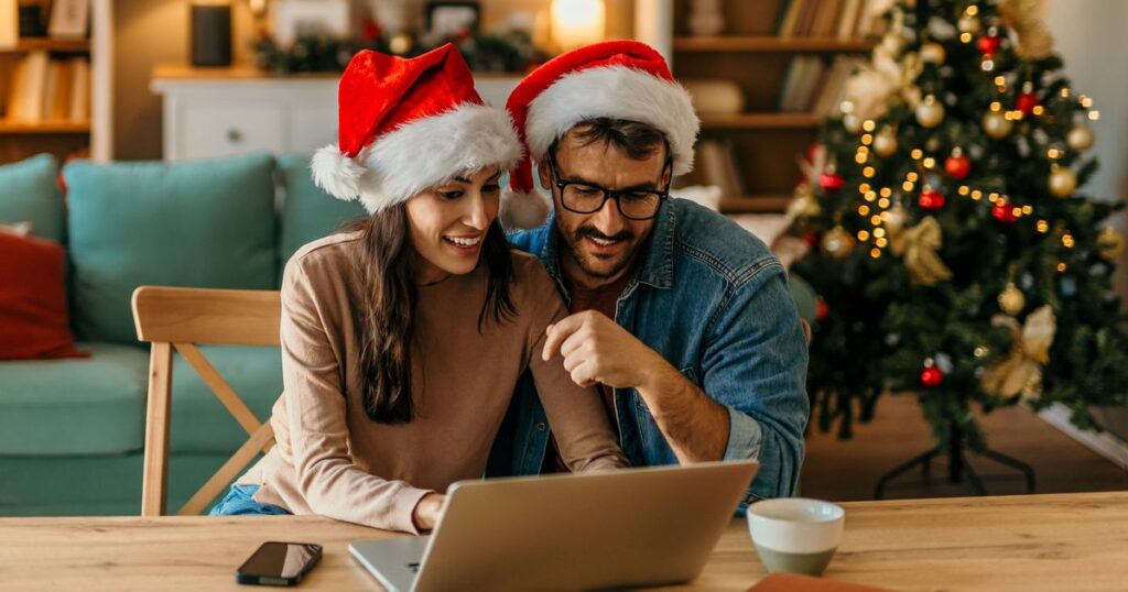 1_Couple-celebrating-christmas-at-home-using-laptop-for-online-shopping.jpg