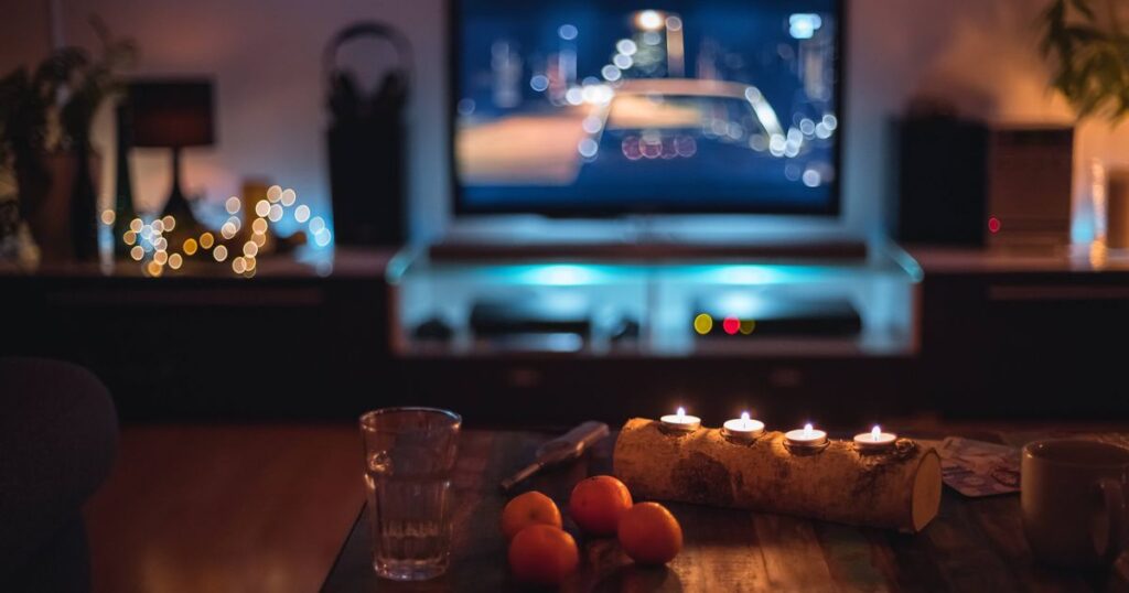 3_Dark-indoor-scene-with-candles-clementines-and-fairy-lights-in-front-of-a-TV-Germany.jpg