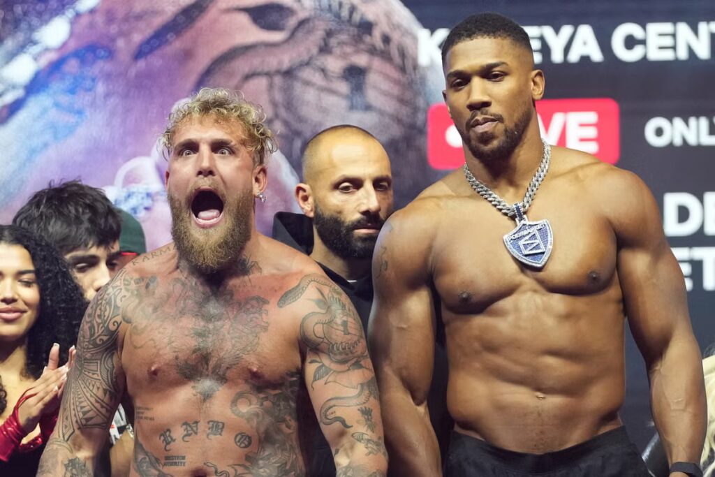 Jake-Paul-left-and-Anthony-Joshua-stand-on-stage-during-a-weigh-in.jpeg