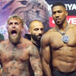 Jake-Paul-left-and-Anthony-Joshua-stand-on-stage-during-a-weigh-in.jpeg