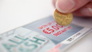 coin-scratching-lottery-scratch-card-547005112.jpg