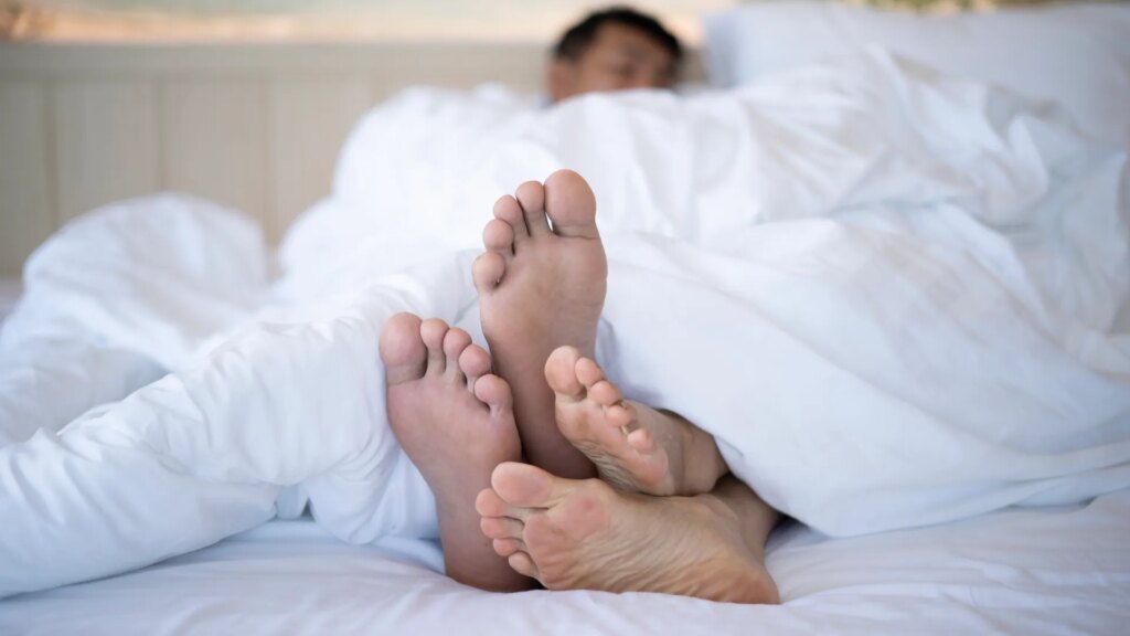 shot-couples-feet-underneath-duvet-1042931650.jpg