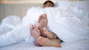 shot-couples-feet-underneath-duvet-1042931650.jpg