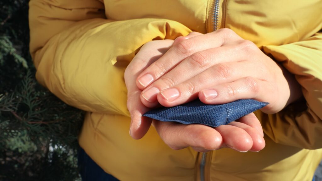 woman-holding-hand-warmer-outdoors-1048429611.jpg