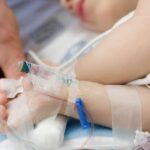 0_Father-holding-hand-of-toddler-in-hospital-hooked-up-to-IV-pulse-ox.jpg