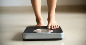 0_Female-leg-stepping-on-weigh-scales-Healthy-lifestyle-food-and-sport-concept.jpg