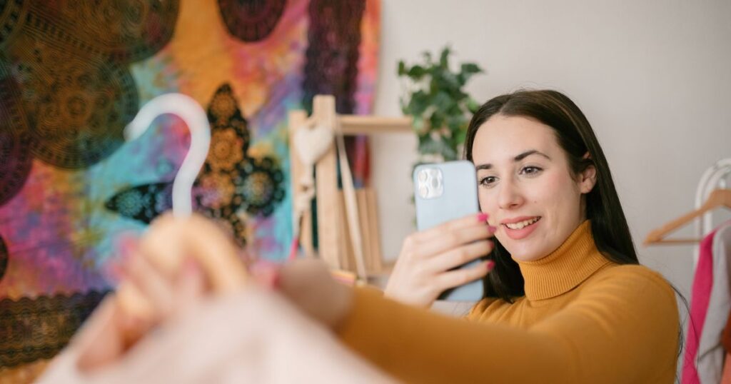 0_Front-view-of-a-young-woman-taking-a-photo-with-her-smartphone-to-a-shirt.jpg